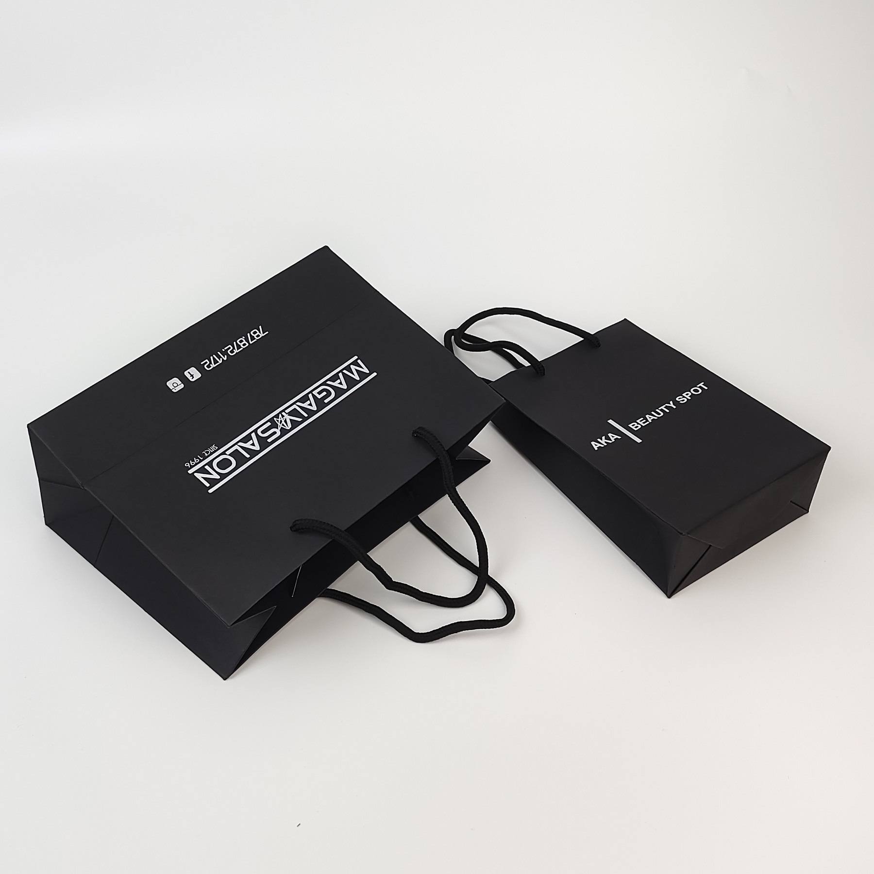 structured black paper shopping bag with silver printed decoration - view 5