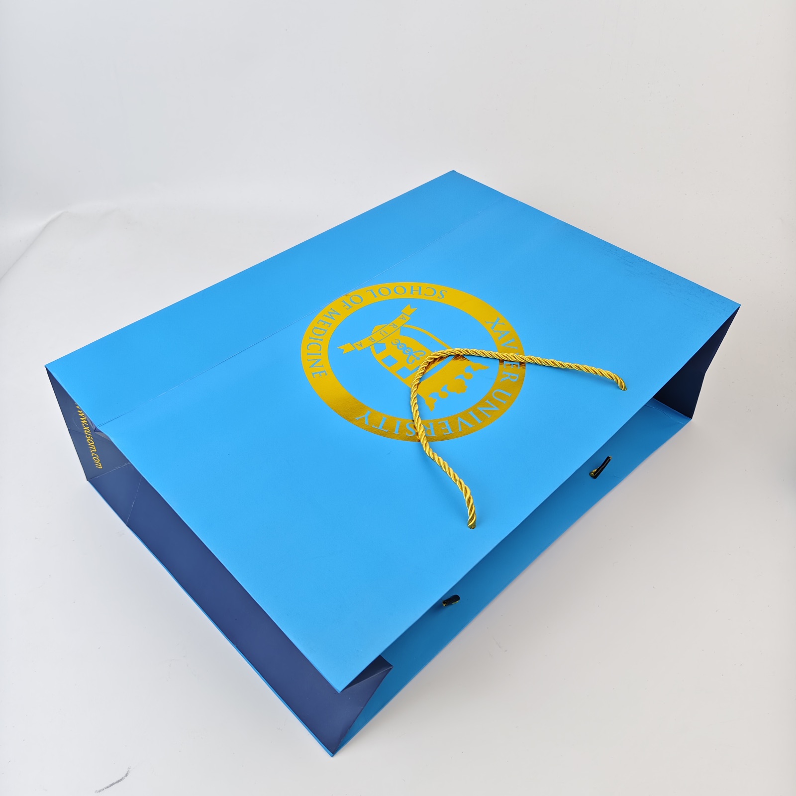 bright blue paper presentation bag with gold foil logo and rope handles - view 4
