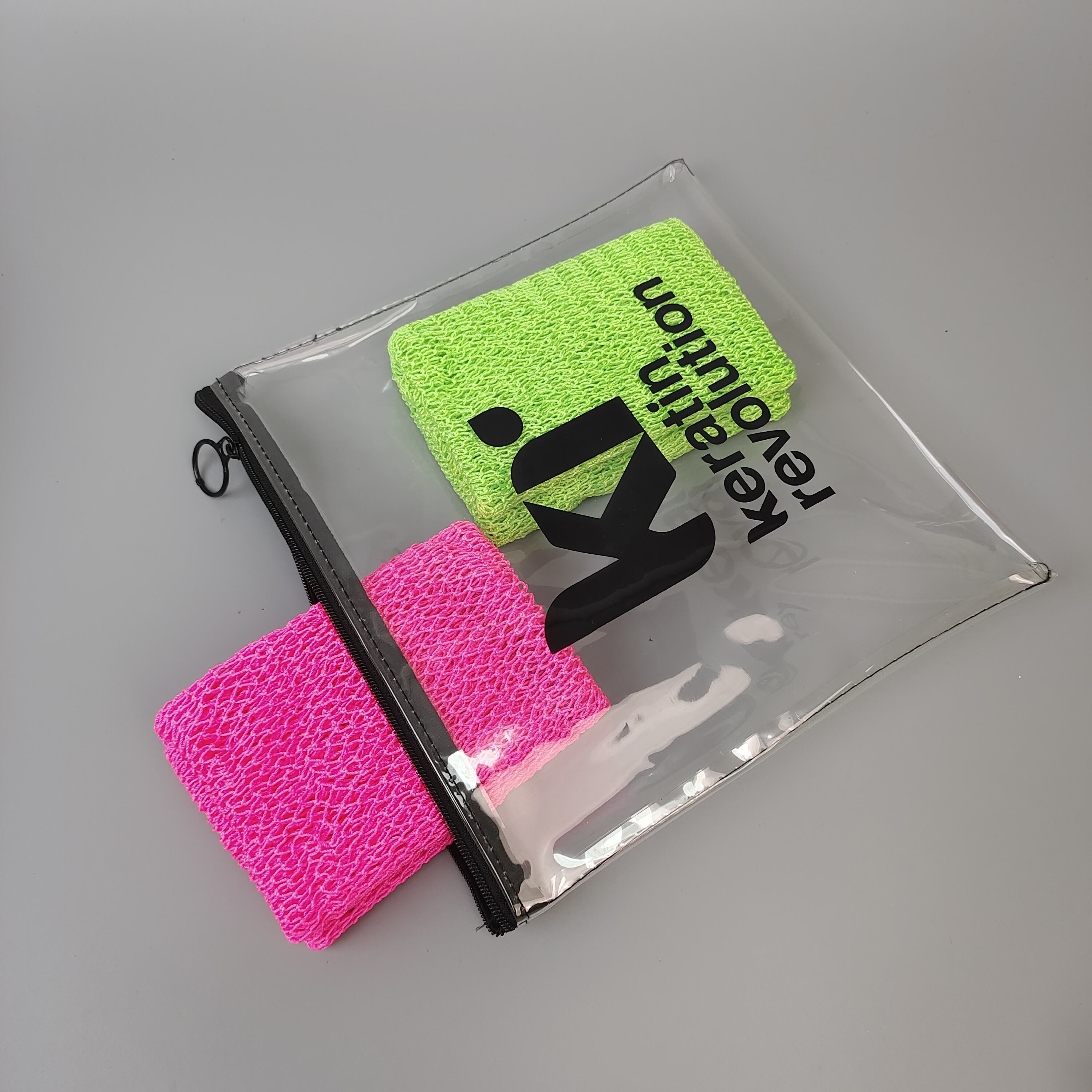 clear printed PVC zipper pouch holding colorful hair care accessories - view 2